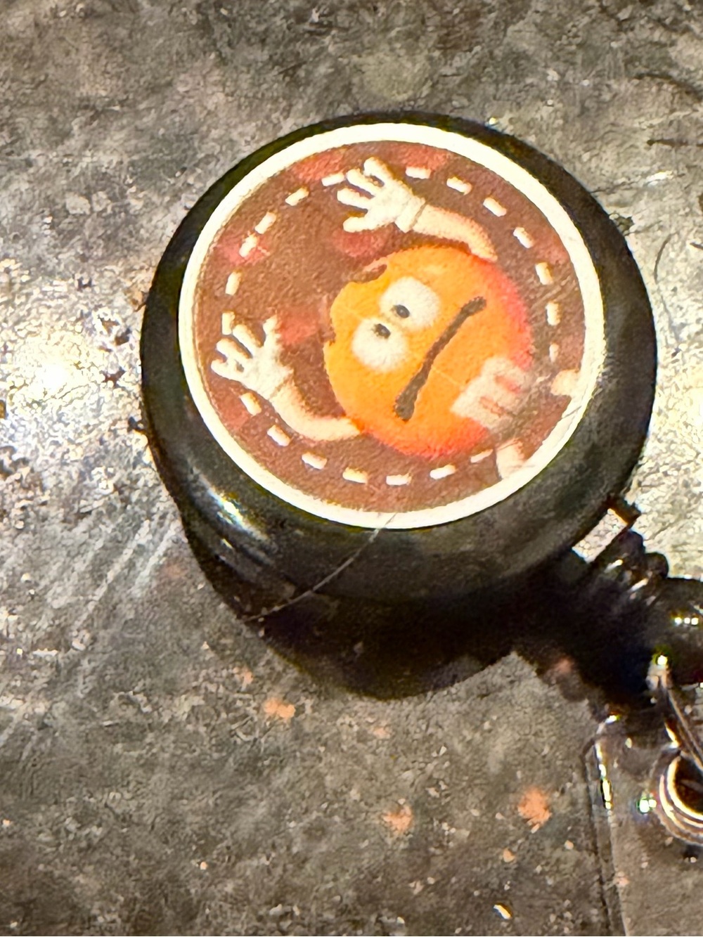 Black Round Retractable Badge Reel with Orange Character Accent